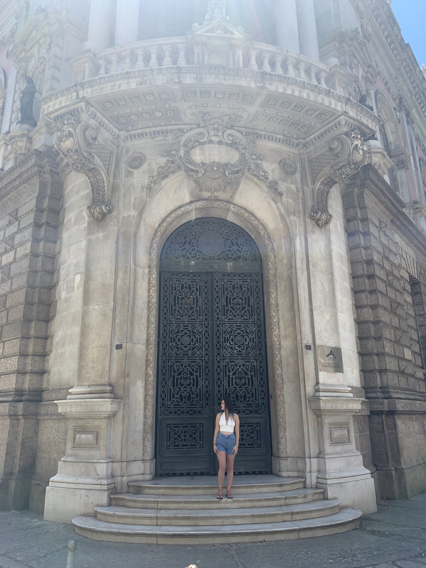 A girl stands in the doorway of an old-fashioned church. The door is giant and round, and there is a balcony and columns above her. Shorts and flip-flops are commonly worn in Rio de Janeiro, and you definitely don't want to forget to pack these.