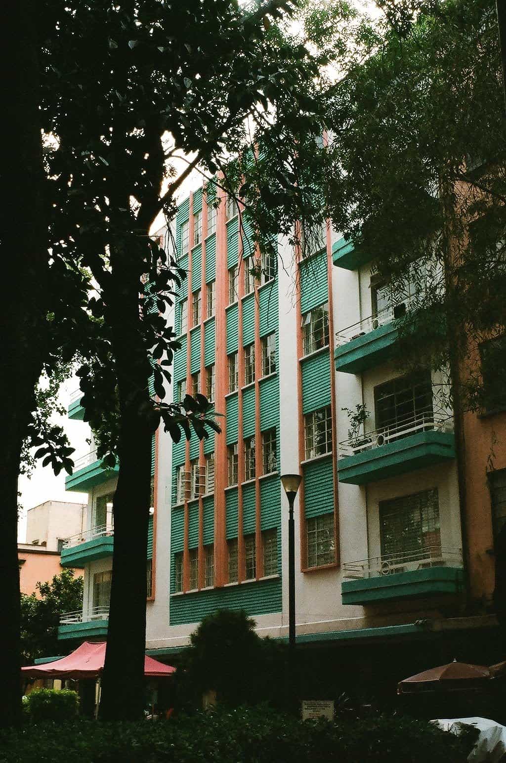 A white building with green and orange details in Mexico City