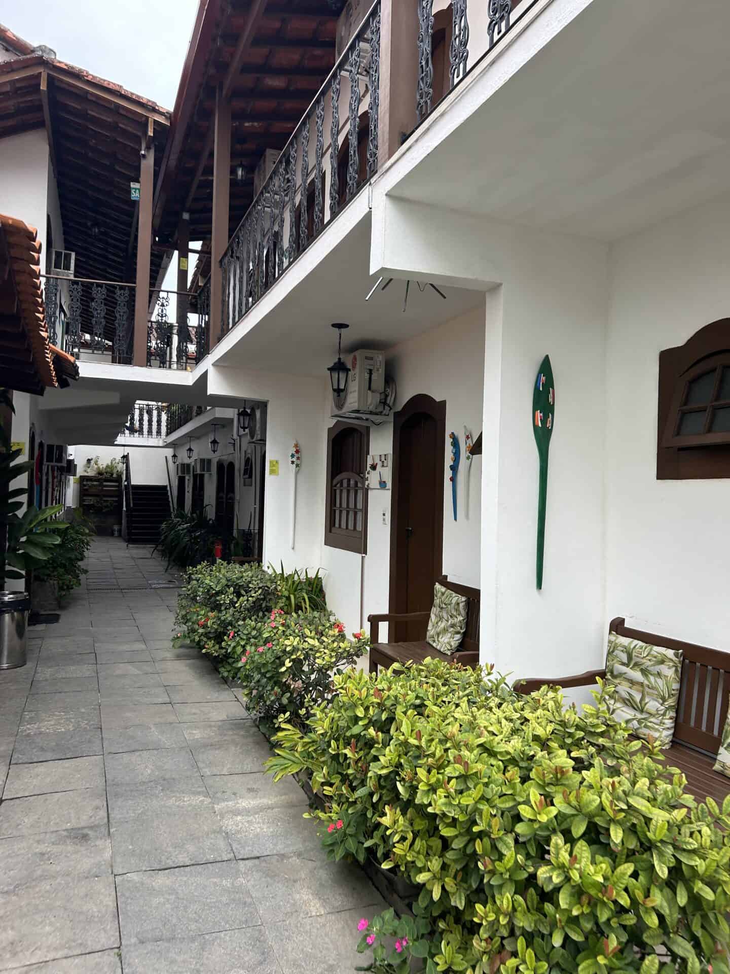 A pousada in Paraty, Brazil. The building is white and it is two floors, with a balcony on the second floor.