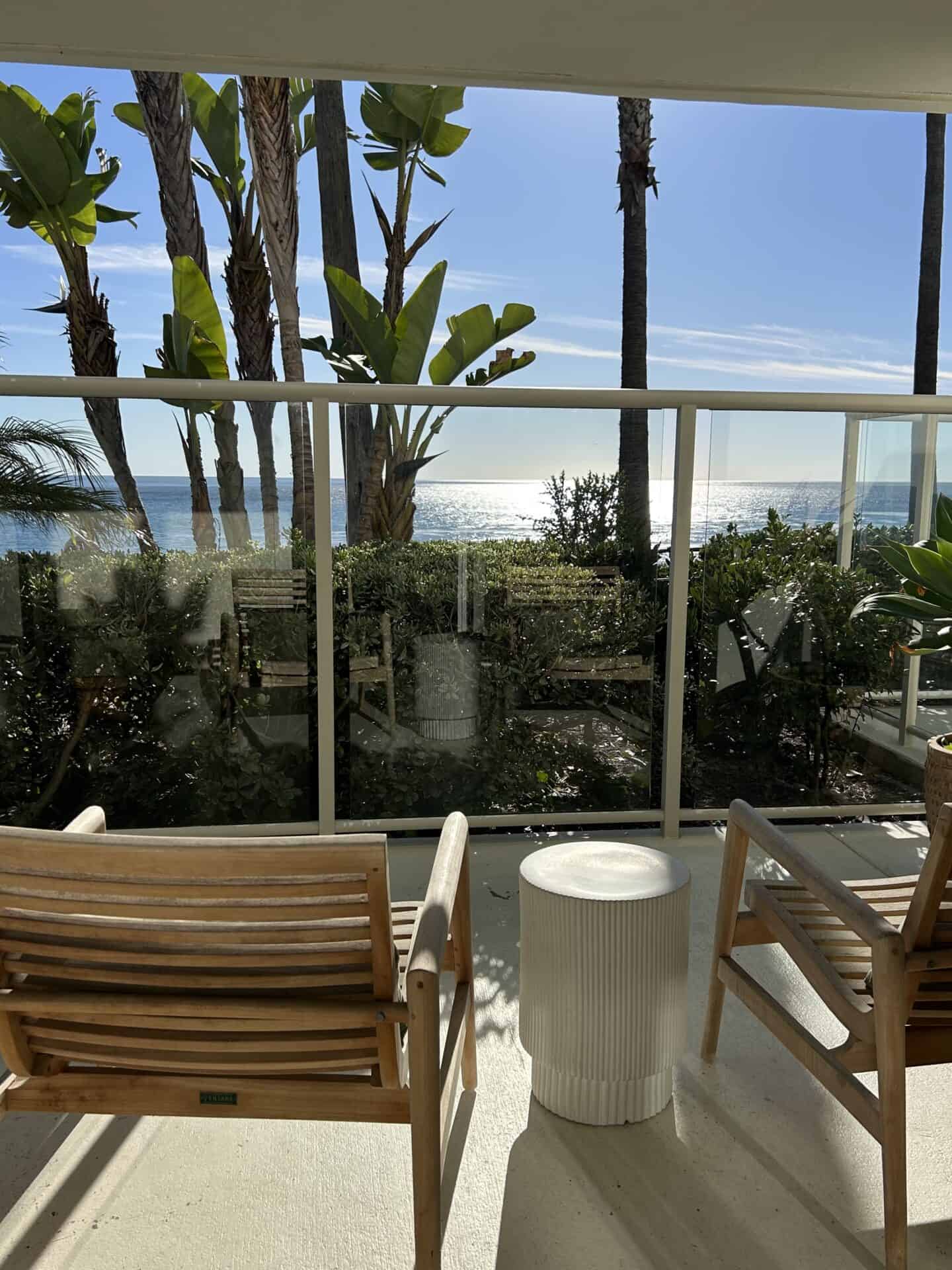 Two chairs and a side table facing the beach in a room of Casa Loma Beach Hotel in Laguna Beach.