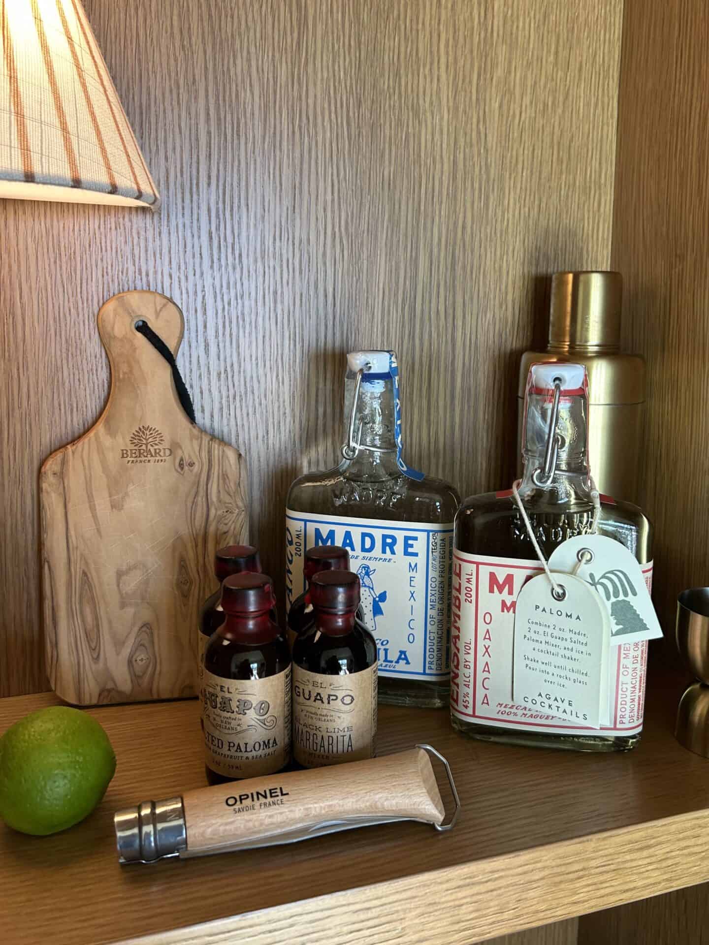 A cutting board, a lime, spirits, and other bar supplies in a Casa Loma Beach Hotel in Laguna Beach room.