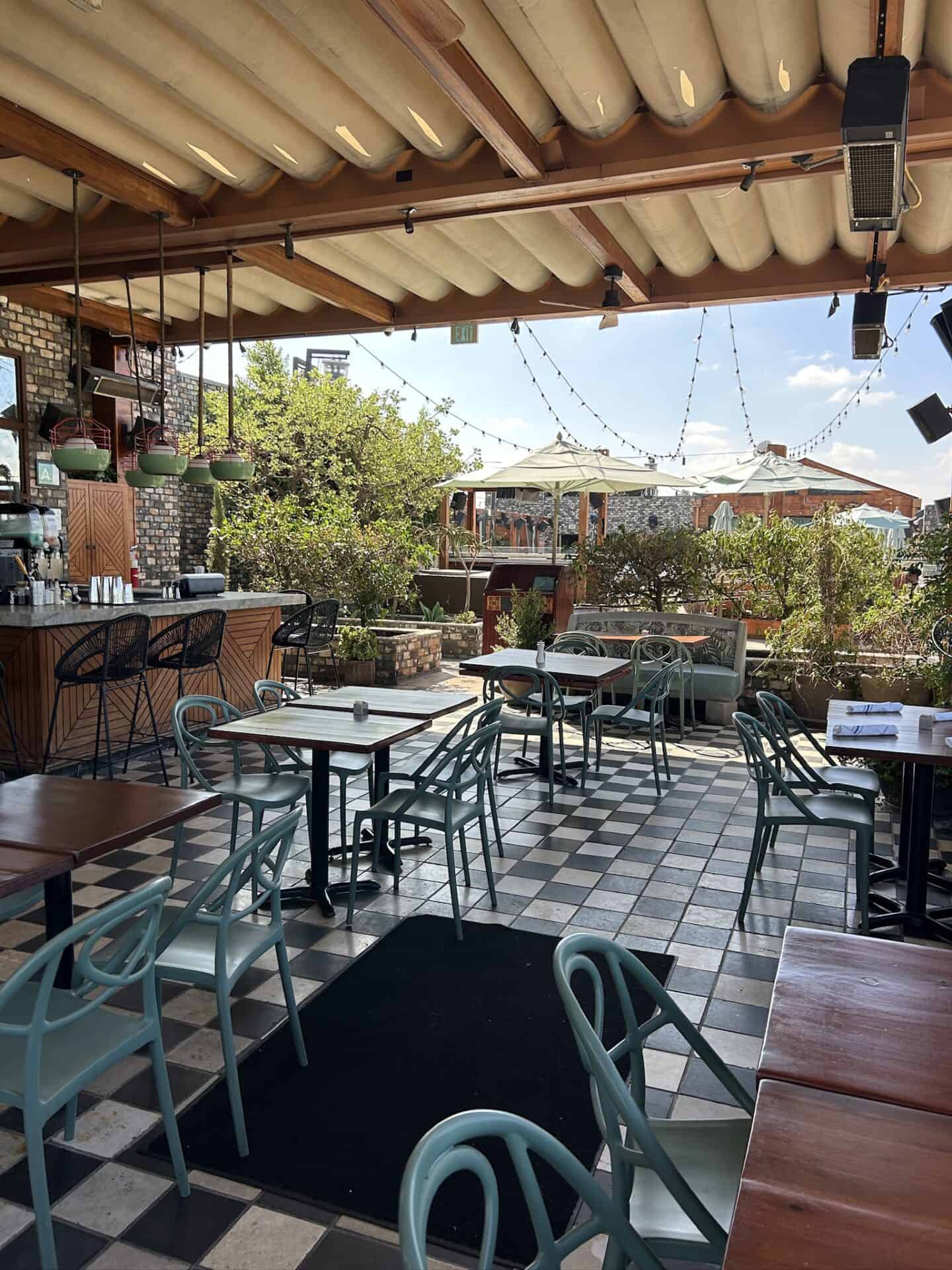 Charming outdoor cafe with checkered tile floor and cozy seating area.